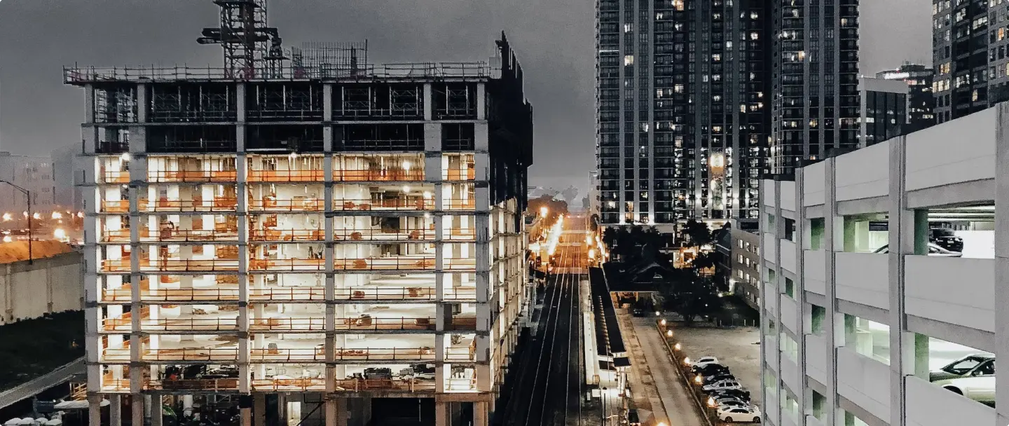 Tall building construction with crane and city train