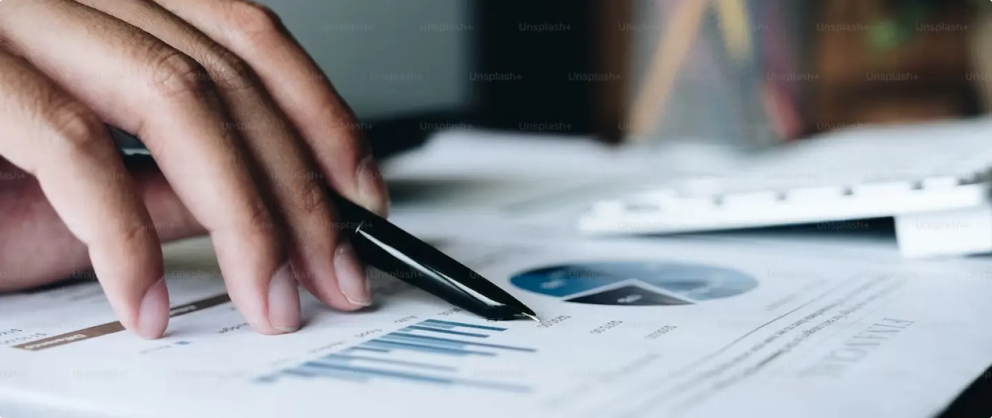 Hand with pen in hand on Financial Report
