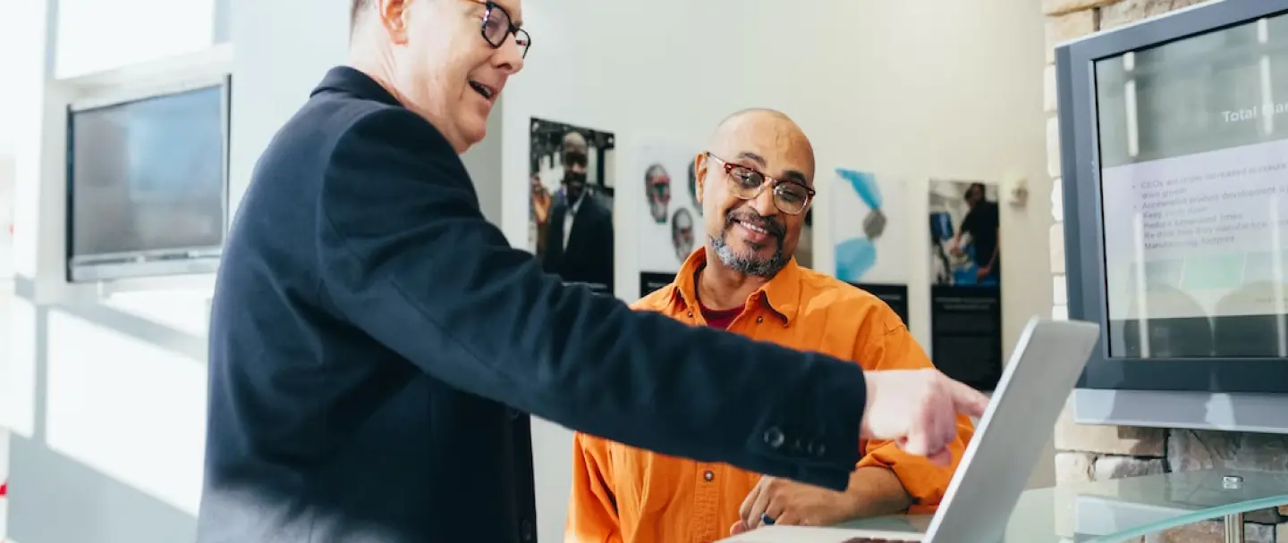 2 men reviewing laptop screen in office