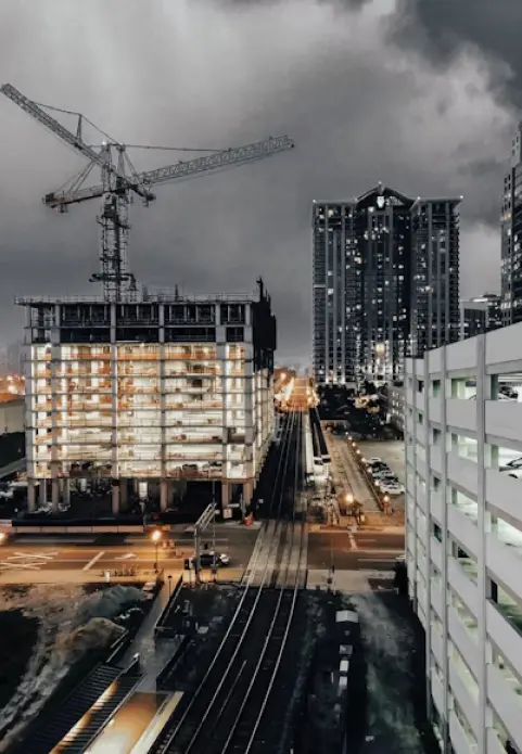 Tall building construction with crane and city train