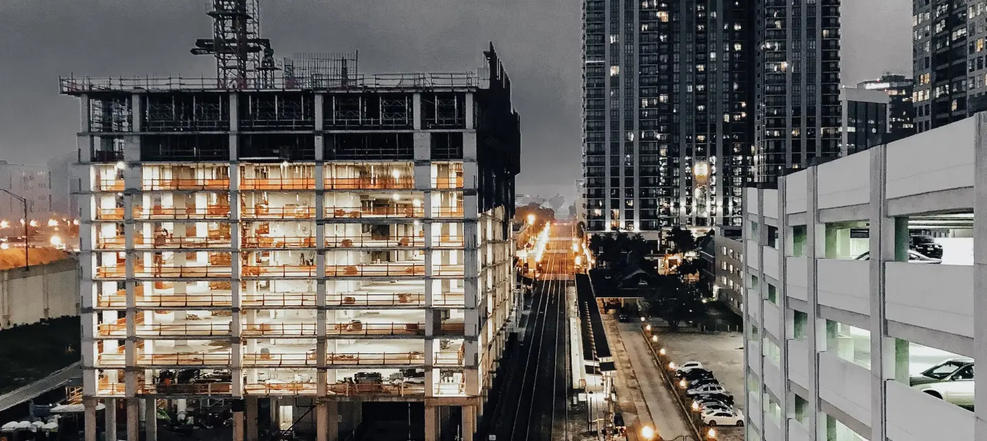 Tall building construction with crane and city train