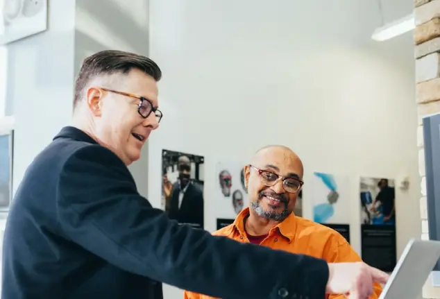 2 men reviewing laptop screen in office